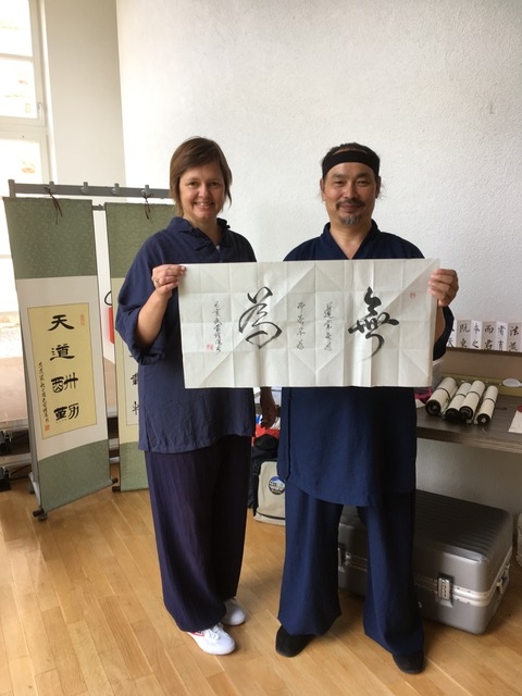 Nicola Maureder (QiHai, Köln) mit Meister Tian Liyang zeigen die Kalligraphie 